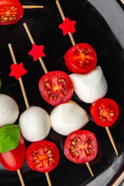 Caprese canaps mozzarella ve domates aperatifli salata şiş parmaklı, lezzetli, sağlıklı yemek aperatifli aperatifler masa üzerinde fotokopi uzay yiyecekleri arka plan kırsal üst görünüm keto veya paleo diyeti 