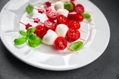 Caprese canaps mozzarella ve domates aperatifli salata şiş parmaklı, lezzetli, sağlıklı yemek aperatifli aperatifler masa üzerinde fotokopi uzay yiyecekleri arka plan kırsal üst görünüm keto veya paleo diyeti 