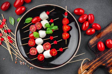 Caprese canaps mozzarella ve domates aperatifli salata şiş parmaklı, lezzetli, sağlıklı yemek aperatifli aperatifler masa üzerinde fotokopi uzay yiyecekleri arka plan kırsal üst görünüm keto veya paleo diyeti 