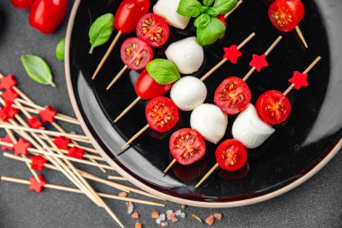 Caprese canaps mozzarella ve domates aperatifli salata şiş parmaklı, lezzetli, sağlıklı yemek aperatifli aperatifler masa üzerinde fotokopi uzay yiyecekleri arka plan kırsal üst görünüm keto veya paleo diyeti 