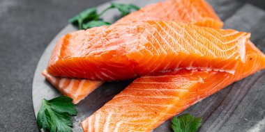  Çiğ somon balığı taze kırmızı balık. Sağlıklı yemek pişiriyor. Masada atıştırmalık şeyler yiyor.