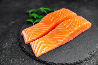  Çiğ somon balığı taze kırmızı balık. Sağlıklı yemek pişiriyor. Masada atıştırmalık şeyler yiyor.