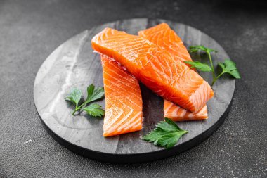  Çiğ somon balığı taze kırmızı balık. Sağlıklı yemek pişiriyor. Masada atıştırmalık şeyler yiyor.
