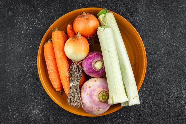 Et suyu için sebze, pırasa, havuç, kereviz, şalgam, taze sağlıklı otlar, iştah açıcı yemek aperatifleri masa üzerinde fotokopi uzay yemeği arka plan kırsal üst görünüm keto veya paleo