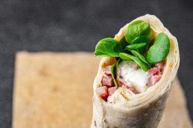 Tortilla dürümü jambon, sebze, peynir, marul lezzetli taze lezzetli sağlıklı yemek iştah açıcı yemek aperatifleri fotokopi masasında uzay yemeği arka plan kırsal manzarası