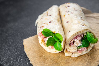 Tortilla dürümü jambon, sebze, peynir, marul lezzetli taze lezzetli sağlıklı yemek iştah açıcı yemek aperatifleri fotokopi masasında uzay yemeği arka plan kırsal manzarası