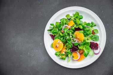 Turunçgil salatası, pancar, yeşil yaprak marul taze sağlıklı yemek atıştırmalıkları fotokopi masasında. 