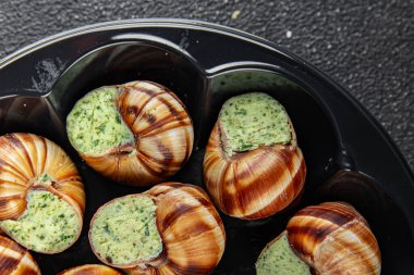 Yeşil yağlı, aromalı salyangozlar lezzetli, sağlıklı, iştah açıcı, yemek aperatifleri fotokopi masasında. Arka plan, kırsal arka plan, üst görüş, keto veya paleo diyeti.