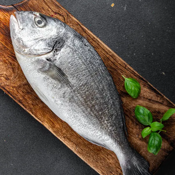 sea bream fish raw seafood tasty fresh healthy eating cooking appetizer meal food snack on the table copy space food background rustic top view keto or paleo diet Pescetarian vegetarian food