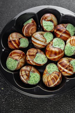 Yeşil yağlı, aromalı salyangozlar lezzetli, sağlıklı, iştah açıcı, yemek aperatifleri fotokopi masasında. Arka plan, kırsal arka plan, üst görüş, keto veya paleo diyeti.