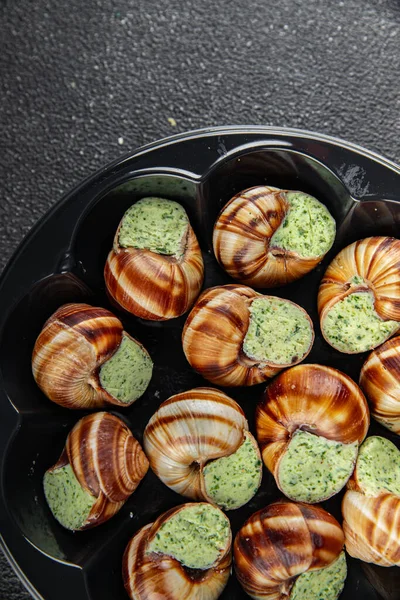 Yeşil yağlı, aromalı salyangozlar lezzetli, sağlıklı, iştah açıcı, yemek aperatifleri fotokopi masasında. Arka plan, kırsal arka plan, üst görüş, keto veya paleo diyeti.