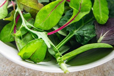 Salata karışımı mikro yeşil, sulu çerez bırakır. Masada sağlıklı yemek pişirir. Arka plandaki yiyeceklerin fotokopisini çeker.
