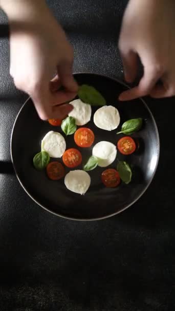 モッツァレラサラダカペラトマト バジル新鮮な食べ物のおいしい食べる前菜の食事の軽食テーブルにコピースペースフードの背景 — ストック動画
