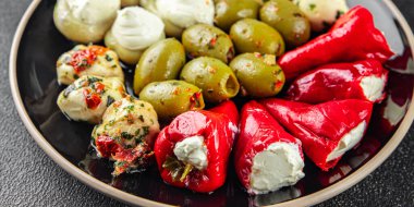 Aperatif sebzeli antipasti zeytin, mozzarella, doldurulmuş biber, mantarlı antipasto taze yemek. Masanın üzerinde yemek atıştırmalığı yemek.