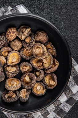 Masanın üzerinde kurutulmuş mantar shiitake yemeği fotokopisi arka planda kırsal manzaralı vejetaryen yemekleri.