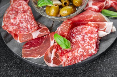 Et tabağı farklı türde salam, prosciutto, sosis, opppa doğal yemek. Masada taze aperatif yemek atıştırmalığı. Fotokopi alanı arka plan kırsal görüş.
