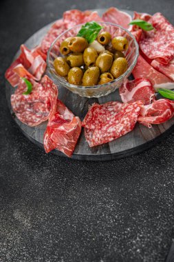 Et tabağı farklı türde salam, prosciutto, sosis, opppa doğal yemek. Masada taze aperatif yemek atıştırmalığı. Fotokopi alanı arka plan kırsal görüş.