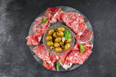 Et tabağı farklı türde salam, prosciutto, sosis, opppa doğal yemek. Masada taze aperatif yemek atıştırmalığı. Fotokopi alanı arka plan kırsal görüş.