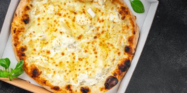 Pizza dört çeşit peynirli mozzarella, mavi peynir, camembert peyniri ve çedar taze yemek atıştırmalığı fotokopi masasında.