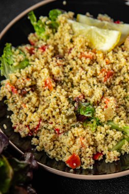 Sebzeli tabbouleh bulgur kuskus. Lezzetli vejetaryen ve vejetaryen yemekleri. Arka planda yemek.