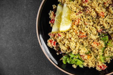 Sebzeli tabbouleh bulgur kuskus. Lezzetli vejetaryen ve vejetaryen yemekleri. Arka planda yemek.