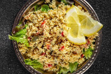 Sebzeli tabbouleh bulgur kuskus. Lezzetli vejetaryen ve vejetaryen yemekleri. Arka planda yemek.