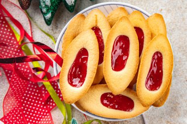 Çilekli reçel teknesi tatlı noel kurabiyeleri lezzetli fırınlanmış ürünler Noel arkaplanı yeni yıl tatili taze yemek abur cuburları masa üzerinde fotokopi uzay yiyecekleri arka plan kırsal manzarası