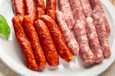 Çiğ sosis, domuz eti, tavuk, kuzu eti, taze lezzetli gurme yemek arkaplanı masanın kırsal kesiminde fotokopi alanı.