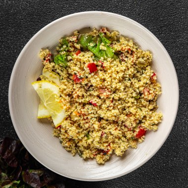 Sebzeli tabbouleh bulgur kuskus. Lezzetli vejetaryen ve vejetaryen yemekleri. Arka planda yemek.