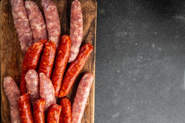 Çiğ sosis, domuz eti, tavuk, kuzu eti, taze lezzetli gurme yemek arkaplanı masanın kırsal kesiminde fotokopi alanı.