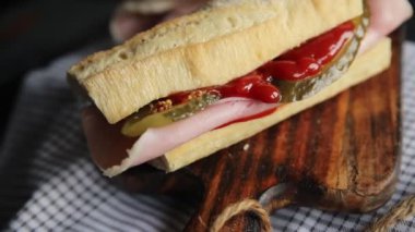 Sandviç, baget, salatalık, salatalık, domates sosu, hardal, fast food taze yemek lezzetli gurme yemek arkaplanı masanın kırsal kesiminde fotokopi odası.