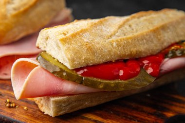 Sandviç, baget, salatalık, salatalık, domates sosu, hardal, fast food taze yemek lezzetli gurme yemek arkaplanı masanın kırsal kesiminde fotokopi odası.