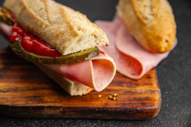 Sandviç, baget, salatalık, salatalık, domates sosu, hardal, fast food taze yemek lezzetli gurme yemek arkaplanı masanın kırsal kesiminde fotokopi odası.