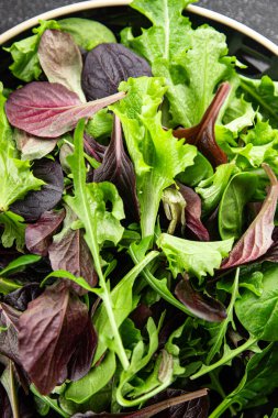 Sağlıklı salata yaprakları karışık salata sulu çerez sebzeler, roka, marul, meşe yaprağı, yeşil yaprak salatası taze yemek arkaplanı masadaki kırsal yiyecekler üst görünüm vejetaryen ve vejetaryen