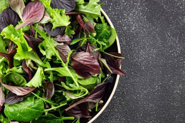 Sağlıklı salata yaprakları karışık salata sulu çerez sebzeler, roka, marul, meşe yaprağı, yeşil yaprak salatası taze yemek arkaplanı masadaki kırsal yiyecekler üst görünüm vejetaryen ve vejetaryen
