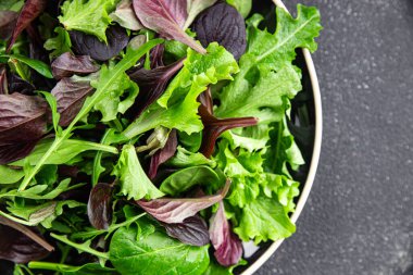 Sağlıklı salata yaprakları karışık salata sulu çerez sebzeler, roka, marul, meşe yaprağı, yeşil yaprak salatası taze yemek arkaplanı masadaki kırsal yiyecekler üst görünüm vejetaryen ve vejetaryen