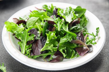 Sağlıklı salata yaprakları karışık salata sulu çerez sebzeler, roka, marul, meşe yaprağı, yeşil yaprak salatası taze yemek arkaplanı masadaki kırsal yiyecekler üst görünüm vejetaryen ve vejetaryen