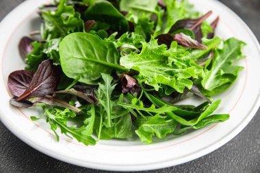 Sağlıklı salata yaprakları karışık salata sulu çerez sebzeler, roka, marul, meşe yaprağı, yeşil yaprak salatası taze yemek arkaplanı masadaki kırsal yiyecekler üst görünüm vejetaryen ve vejetaryen