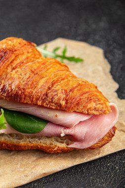 Kruvasan sandviçi, jambon, peynir, yeşil yaprak salatası lezzetli gurme yemek arkaplanı masa kırsal yiyeceklerin üst görünümü fotokopi alanı