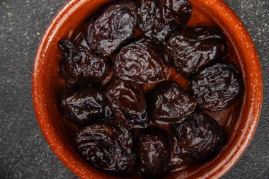 Kurutulmuş kuru erik, kurutulmuş erik ve gurme yemek arka planda masada rustik gıda fotokopi alanı keto ve paleo diyet vejetaryen ve vejetaryen gıda