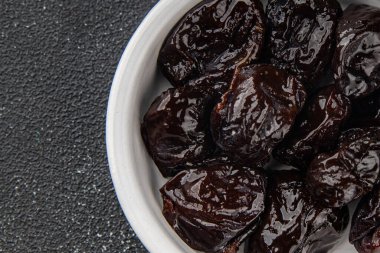 Kurutulmuş kuru erik, kurutulmuş erik ve gurme yemek arka planda masada rustik gıda fotokopi alanı keto ve paleo diyet vejetaryen ve vejetaryen gıda