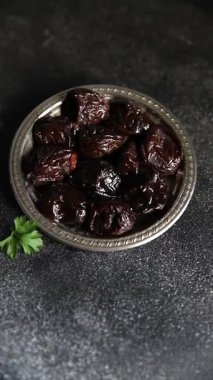 Kurutulmuş kuru erik, kurutulmuş erik ve gurme yemek arka planda masada rustik gıda fotokopi alanı keto ve paleo diyet vejetaryen ve vejetaryen gıda