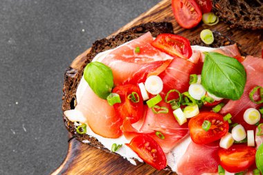 Jambon, domates, yeşillik taze lezzetli gurme yemek arkaplanı masa kırsal yiyeceklerin üst görünümü fotokopi alanı.