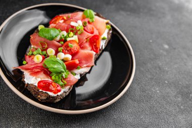 Jambon, domates, yeşillik taze lezzetli gurme yemek arkaplanı masa kırsal yiyeceklerin üst görünümü fotokopi alanı.