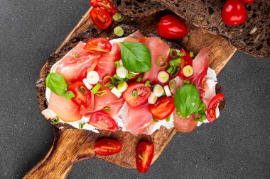 Jambon, domates, yeşillik taze lezzetli gurme yemek arkaplanı masa kırsal yiyeceklerin üst görünümü fotokopi alanı.