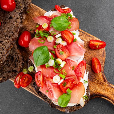 Jambon, domates, yeşillik taze lezzetli gurme yemek arkaplanı masa kırsal yiyeceklerin üst görünümü fotokopi alanı.