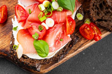 Jambon, domates, yeşillik taze lezzetli gurme yemek arkaplanı masa kırsal yiyeceklerin üst görünümü fotokopi alanı.