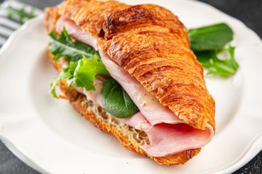 Sandviç kruvasan jambon, peynir, yeşil yaprak salatası lezzetli gurme yemek arkaplanı masa kırsal yiyeceklerin üst görünümü fotokopi alanı.