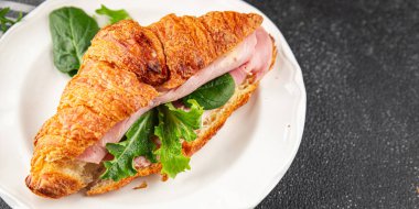 Sandviç kruvasan jambon, peynir, yeşil yaprak salatası lezzetli gurme yemek arkaplanı masa kırsal yiyeceklerin üst görünümü fotokopi alanı.