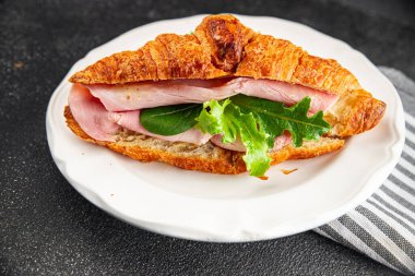 Sandviç kruvasan jambon, peynir, yeşil yaprak salatası lezzetli gurme yemek arkaplanı masa kırsal yiyeceklerin üst görünümü fotokopi alanı.